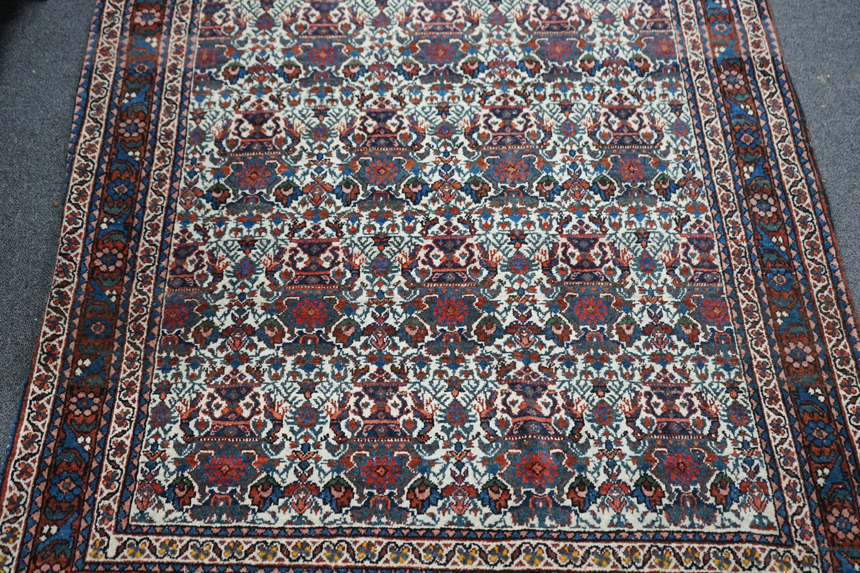 A Persian blue ground rug decorated with Zil-i-Soltan motifs on ivory fields, 106 x 152cm